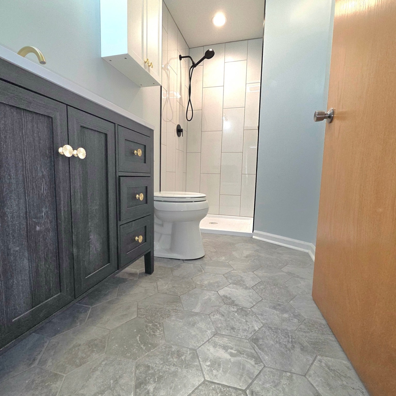 Finished bathroom with custom vanity and tiled floor
